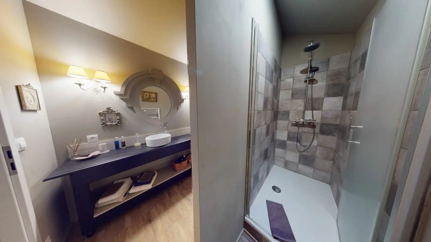 Salle d'eau rénovée à Arnaville : meuble vasque, miroir ancien et douche carrelée
