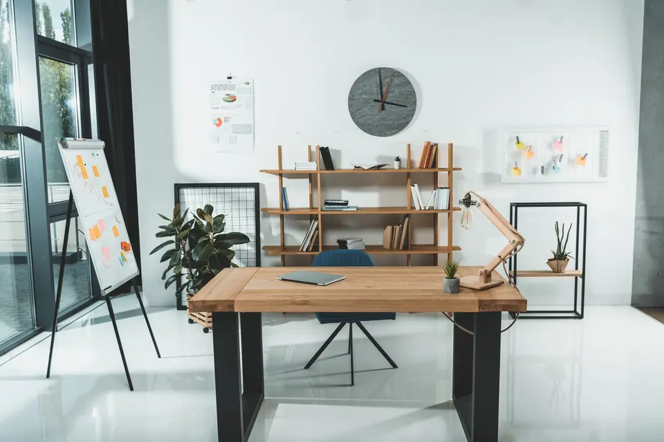 Bureau professionnel lumineux : table en bois, étagère, tableau de papier et grande baie vitrée