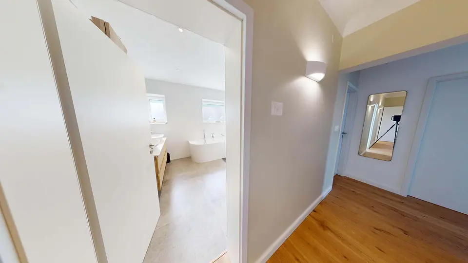 Entrée de la salle de bain de Plappeville après travaux, vue depuis le couloir au parquet en chêne