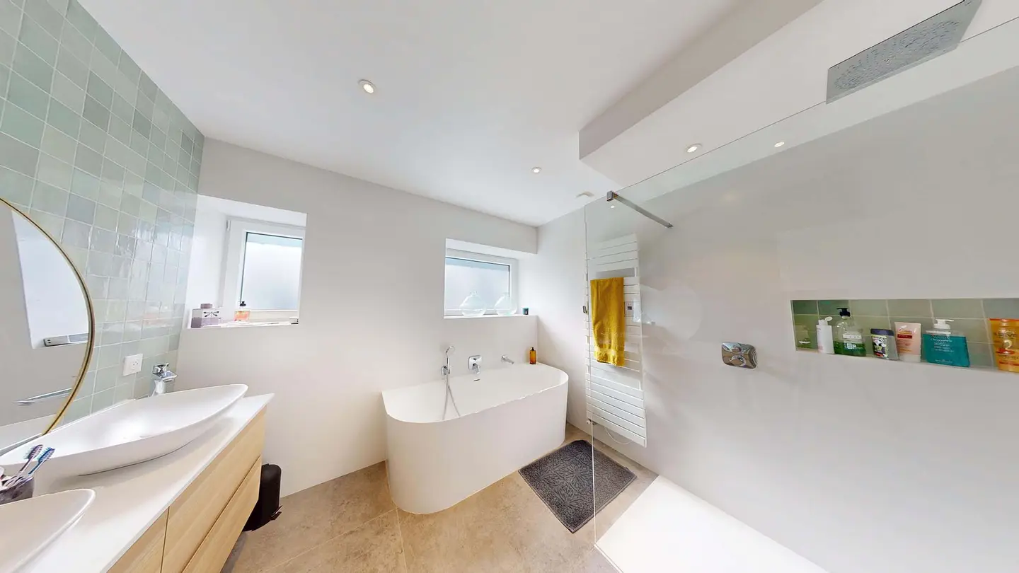 La salle de bain de Plappeville après travaux : double vasque, baignoire îlot, douche à l'italienne vitrée et niche carrelée
