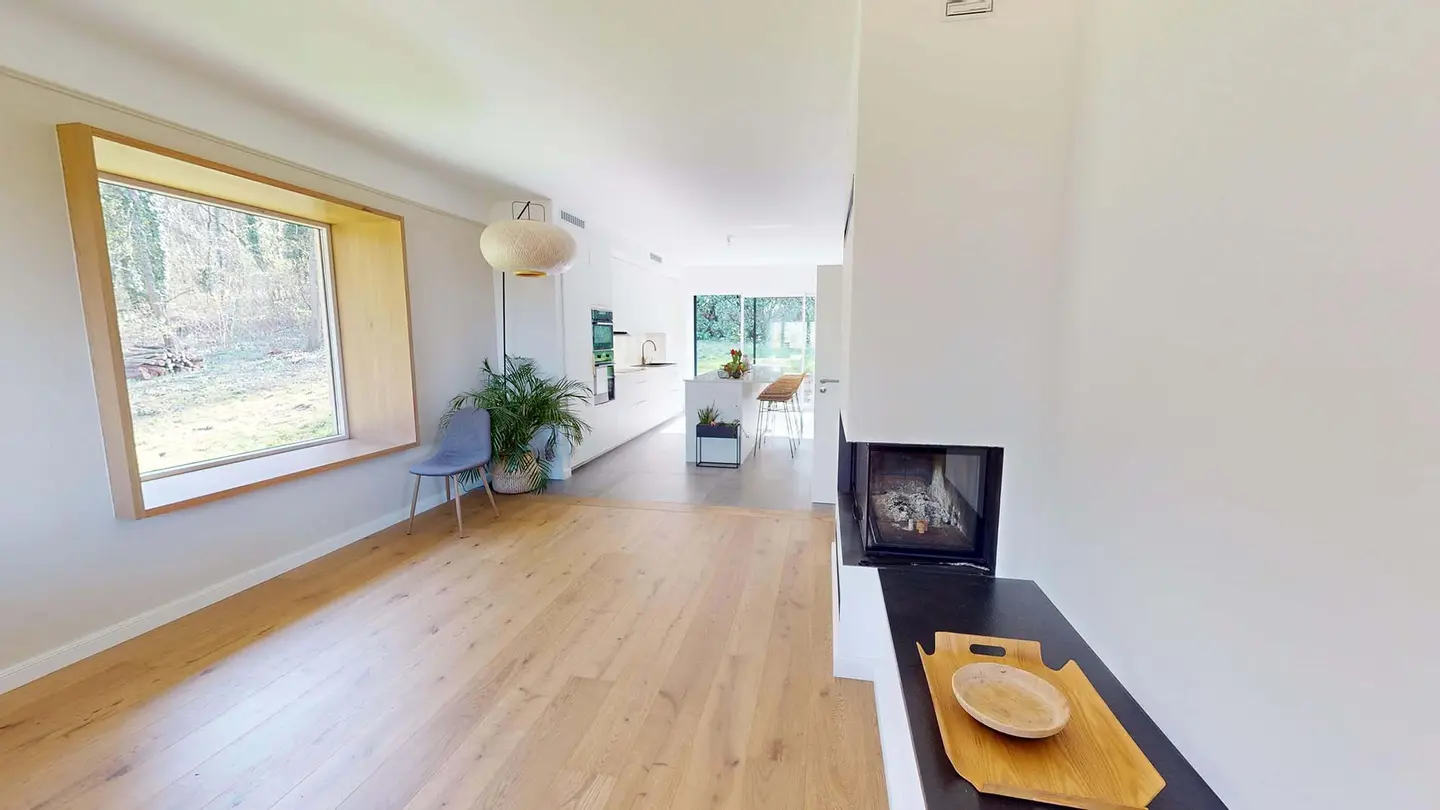 Séjour rénové à Plappeville : parquet clair, grande baie encadrée de bois et cheminée à foyer vitré