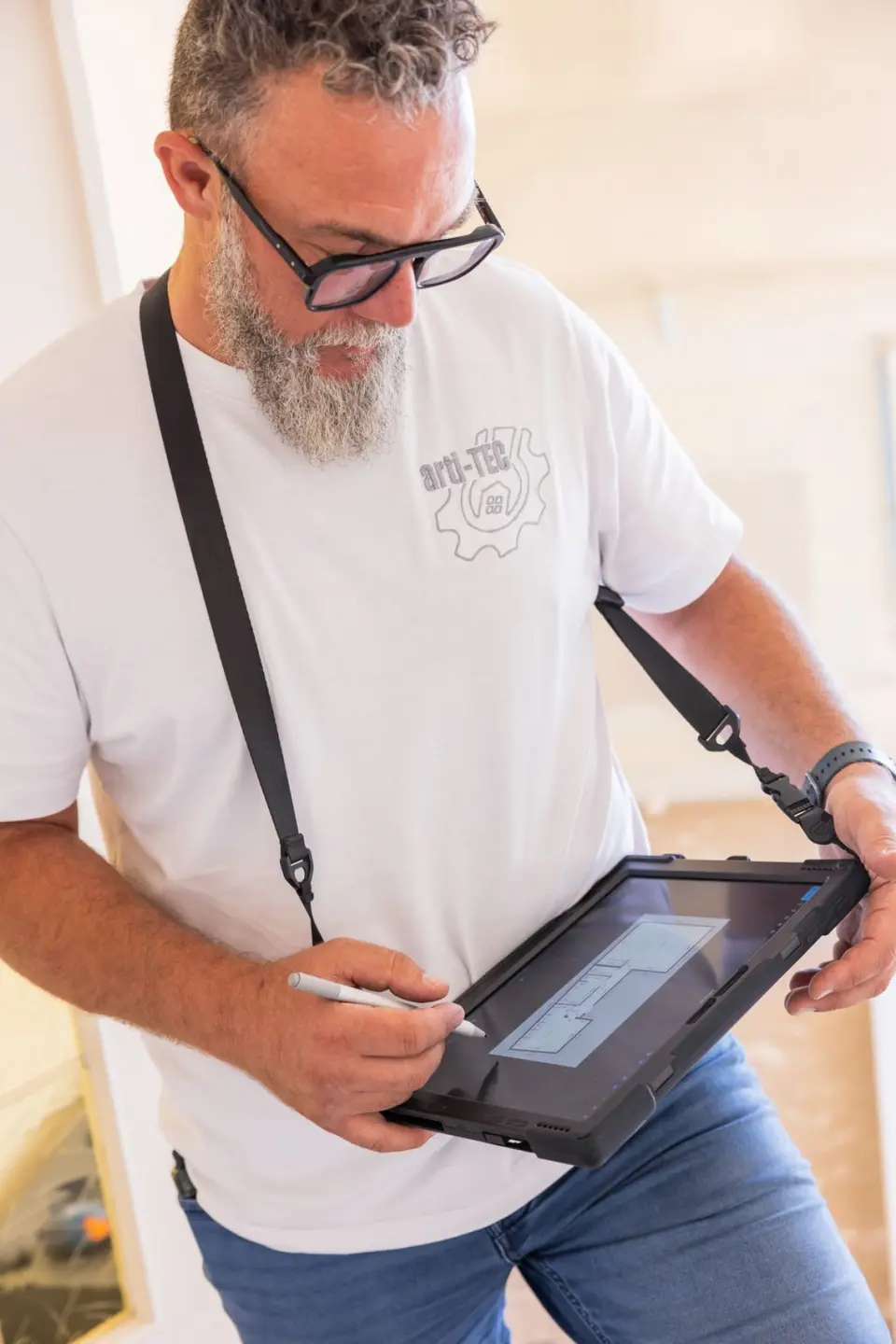 Sébastien Milone prend des notes sur sa tablette pendant une visite de chantier